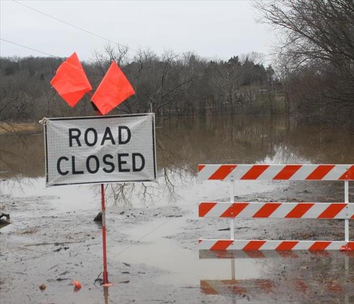 Road closed due to flooding sign with flooded area 